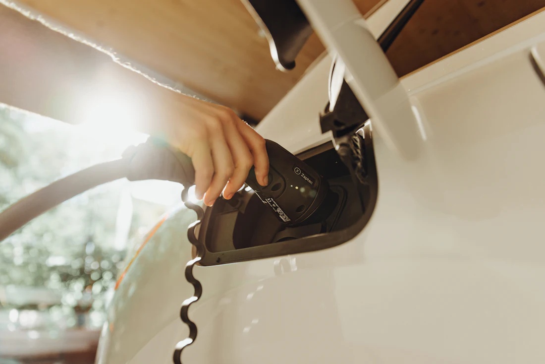 Main branchant le câble de recharge d'une voiture électrique