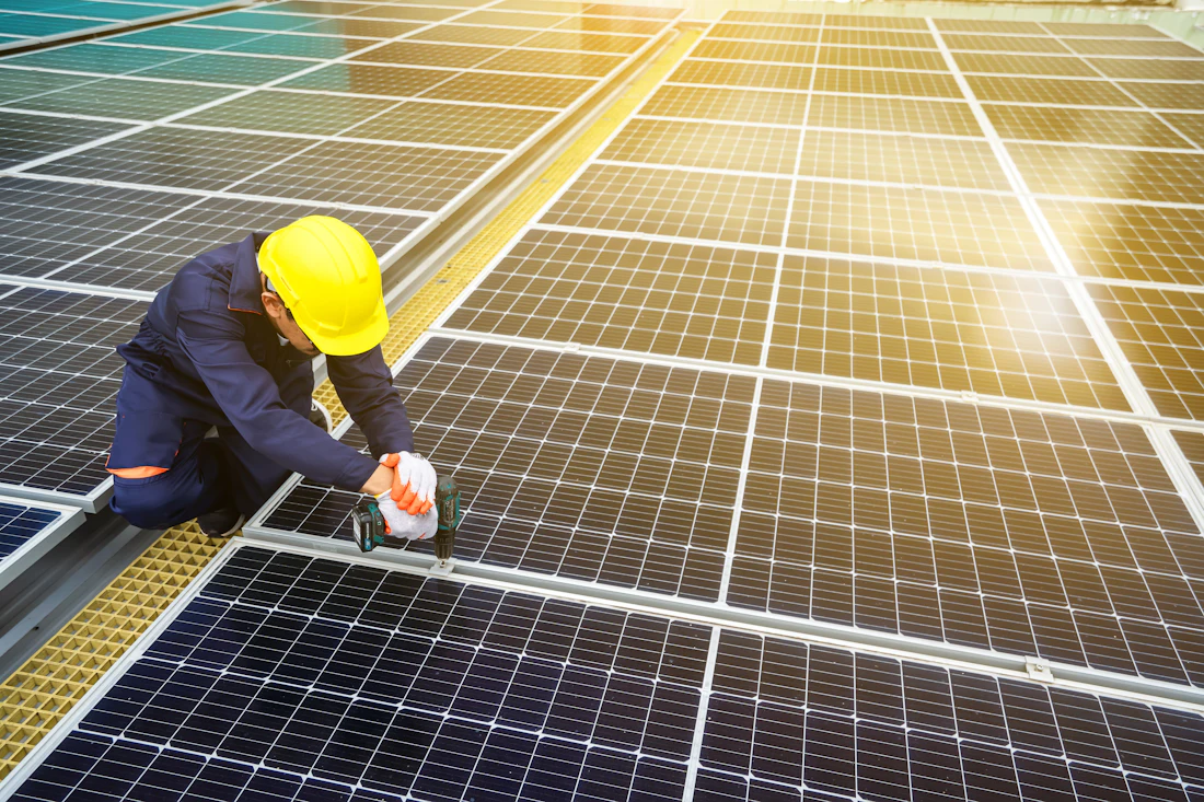 Technicien casqué contrôlant des panneaux solaires