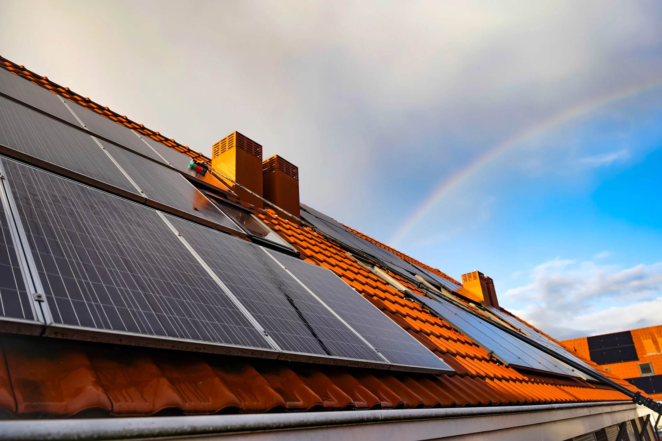 Toit en tuiles équipé de panneaux solaires dans la lumière dorée du soir